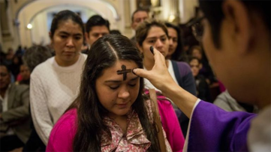 Fieles reciben la imposición de la ceniza en una iglesia católica, marcando el inicio de la Cuaresma.